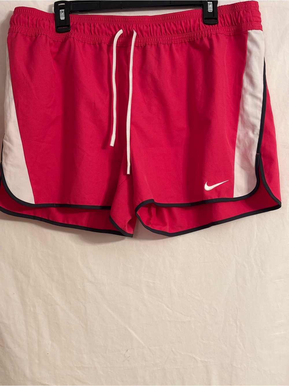Nike Dri-fit pink athletic shorts with white side panels, elastic waistband.